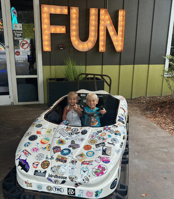 Kids sitting in a model car at Charleston Fun Park