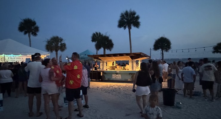 Families enjoying the evening at Party at the Point with food vendors, palm trees, and string lights on the beach at Charleston Harbor Resort, Mount Pleasant SC