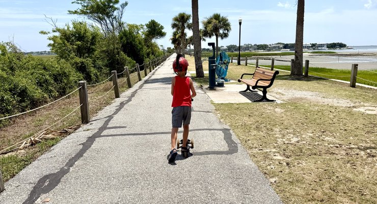 Kid riding scooter on the Pickett Park greenway at Pitt Street Bridge in Mount Pleasant SC