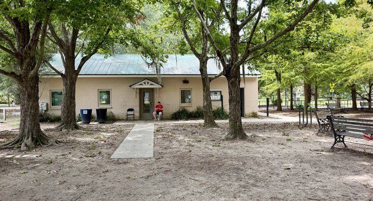 McMahon Playground equipment with hydrangea bushes along brick fence background Charleston SC