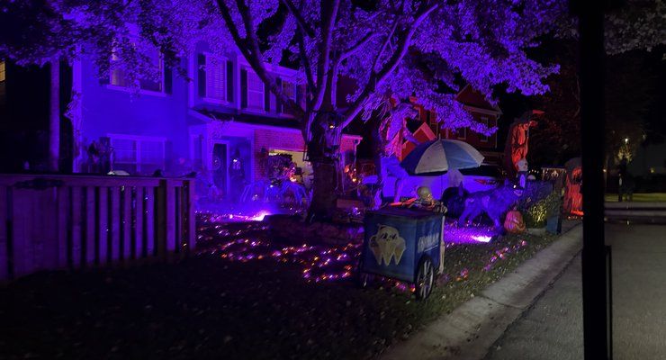 Spooky ice cream cart in a yard lit with purple lights under a tree in a Charleston, SC neighborhood at Halloween