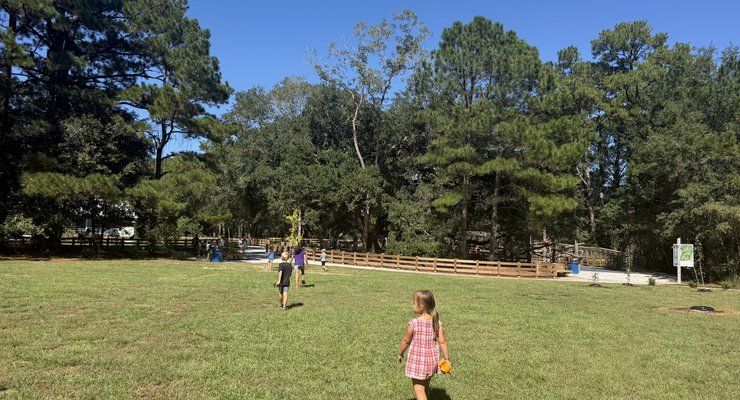 Children playing on the open grassy lawn at Old Towne Creek County Park