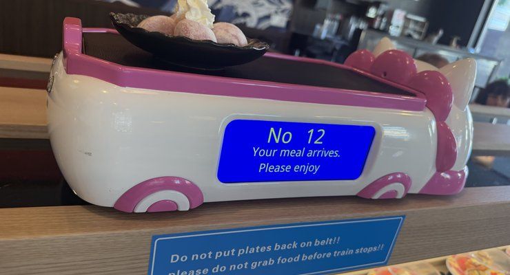 Pink cat-shaped delivery train carrying a plate at Revolving Sushi Kingdom in Mount Pleasant