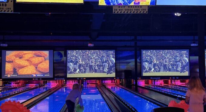 Glowing bowling lanes with video screens overhead at Stars and Strikes in Summerville, SC