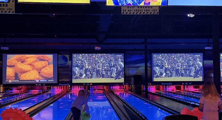 Glowing bowling lanes with video screens overhead at Stars and Strikes in Summerville, SC
